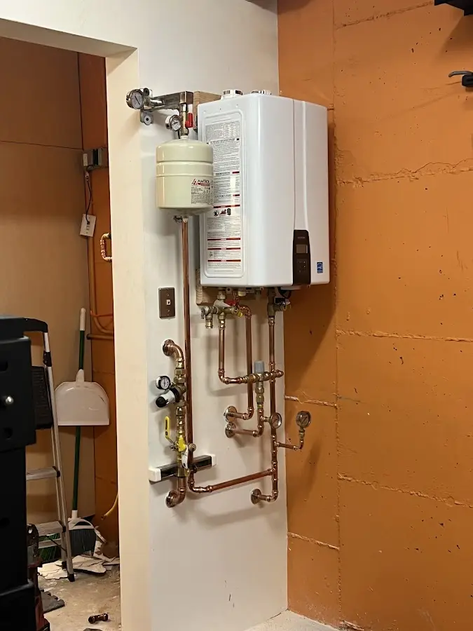 Plumbing technician inspecting water heater connections in Fairfax